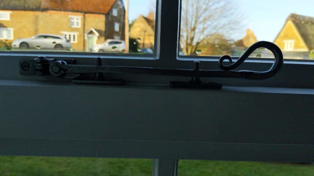 Hand-forged bronze casement window stay on restored period window in Wardington Oxfordshire